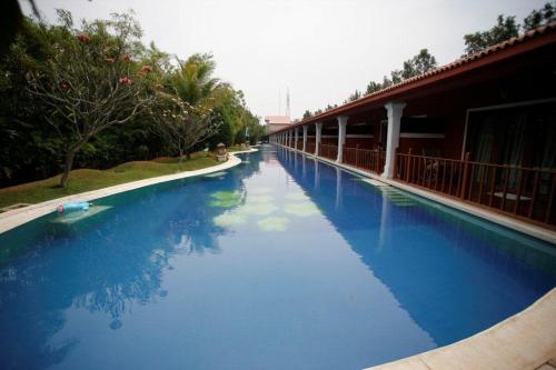 a swimming pool with blue water in front of a building at Lagoon Bay Hotel at Leonia in Secunderabad