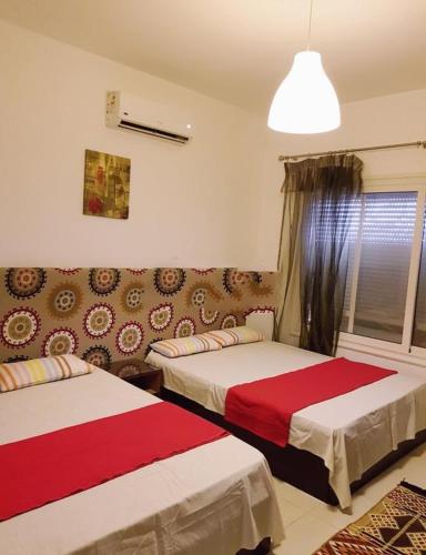 a bedroom with two beds and a couch at VIP Chalet Amwaj North Cost E Zone The Terrace in El Alamein