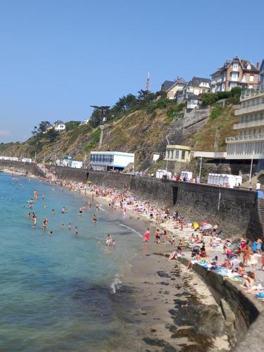 un groupe de personnes sur une plage dans l'eau dans l'établissement Plat Gousset, à Granville