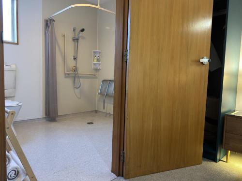an open door to a bathroom with a shower at ASURE Ambassador Motor Lodge in Oamaru