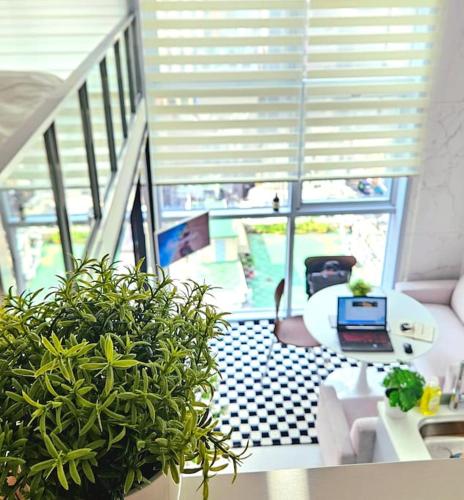a living room with a couch and a table with a laptop at Majestic Seoul Stay Central in Seoul