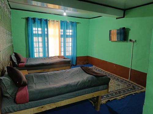 a room with two beds and a couch in it at Padmaling guest house zanskar eco camp in Padam