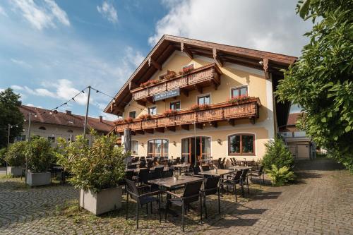 a restaurant with tables and chairs in front of a building at Gasthof Gruber in Fridolfing