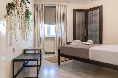 a bedroom with a bed and a table and a window at GRAND SUITE by F & G in Kastoria