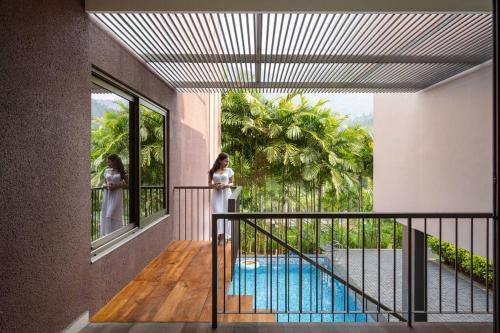 a balcony with a view of a swimming pool at 2 premium rooms with pool&by lake close to Vagamon in Muttam