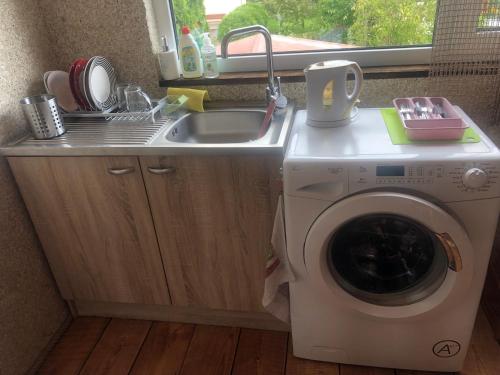 a kitchen with a washing machine and a sink at Sweet Honey homestay in Jūrmala