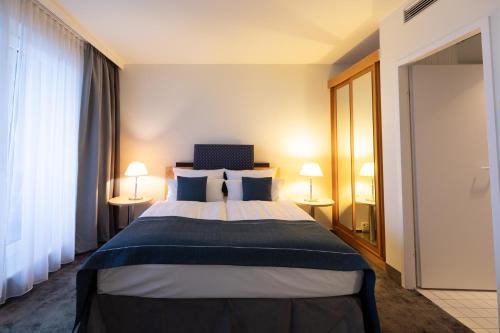a hotel room with a bed and two lamps at Garner Hotel Rüsselsheim by IHG in Rüsselsheim