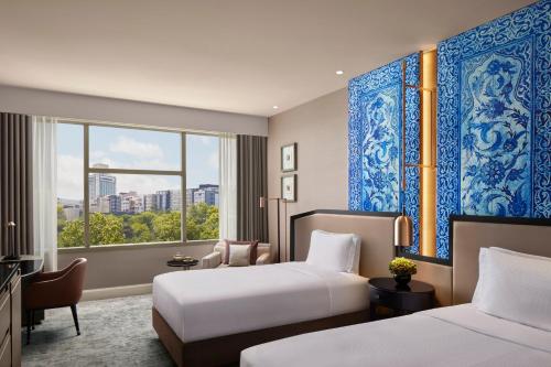 a hotel room with two beds and a window at The Ritz-Carlton, Istanbul at the Bosphorus in Istanbul