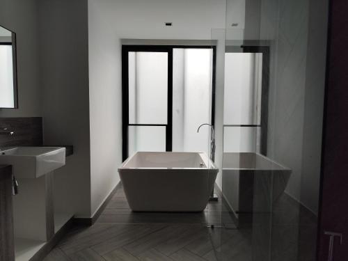 a bathroom with a bath tub and a sink at Lumi Tropicana in Petaling Jaya