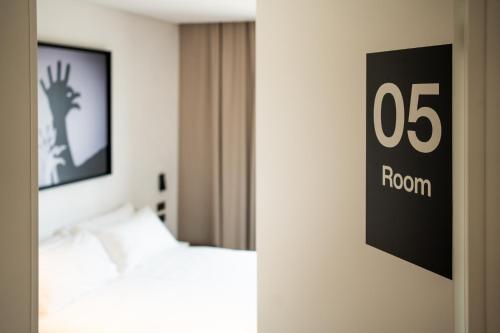 a room with a bed and a sign on the wall at MòN Luxury Rooms SPA in Nicolosi
