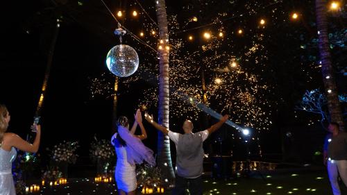 a group of people standing in front of a tree with lights at Villa Manis Beachfront Candidasa in Candidasa