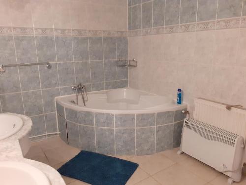 une salle de bain avec une baignoire et un lavabo dans l'établissement Holiday cosy house, à Eymet