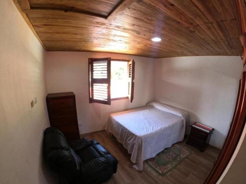 a bedroom with a bed and a window and a chair at Hospedaje Villa Valencia en Los Patos in Los Patos