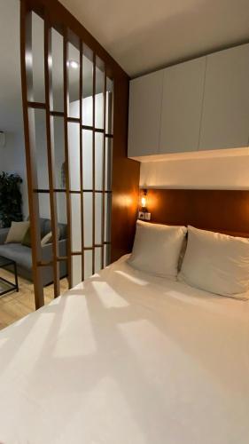 une chambre avec un grand lit avec des oreillers blancs dans l'établissement Joli studio au cœur de Paris, à Paris