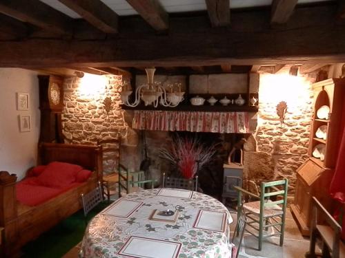 un salon avec une table et une cheminée dans l'établissement Petite maison traditionnelle, à Savennes
