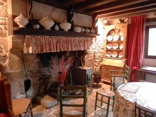 - un salon avec une cheminée, une table et des chaises dans l'établissement Petite maison traditionnelle, à Savennes