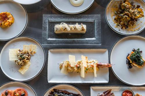 a table topped with plates of food on plates at VIVOOD Landscape Hotel & Spa - Designed for Adults in Benimantell