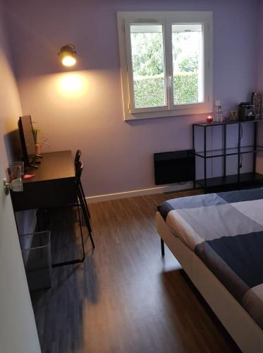 ein Schlafzimmer mit einem Bett, einem Schreibtisch und einem Fenster in der Unterkunft Chambre Proche Astérix, Parc Expo Villepinte, CDG, Bourget in Saint-Witz