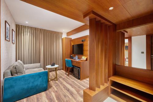 a living room with a blue couch and a desk at Q-White Crescent in Cochin