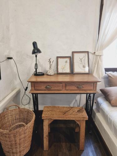 a desk with two pictures on it next to a couch at Naturetalk Homestay in Ban Don