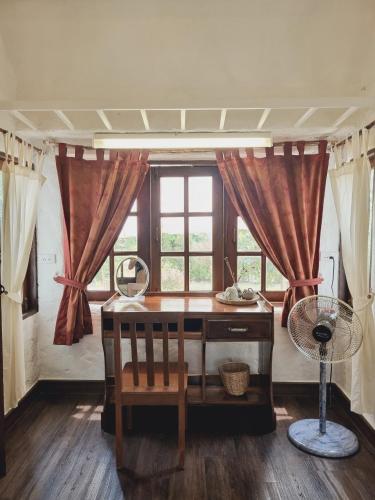 a desk in front of a window with a fan at Naturetalk Homestay in Ban Don