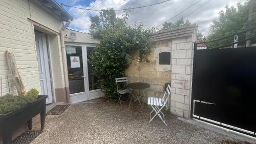 a patio with a table and chairs next to a building at Mini studio et espace extérieur in Méry-sur-Oise