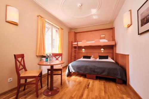 a bedroom with a bed and a table and a chair at JUFA Hotel Meersburg am Bodensee in Meersburg