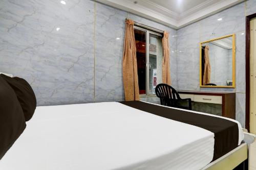 a bedroom with a bed in a room with a window at Spot On Sri Balaji in Vijayawāda