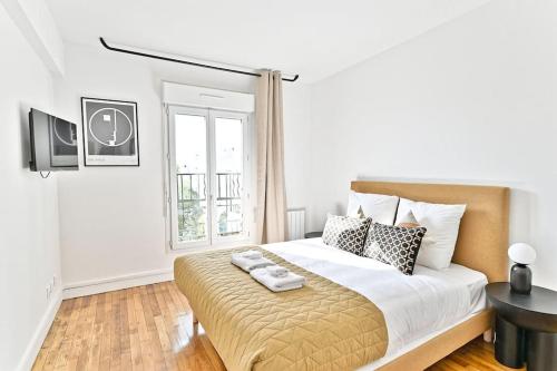 une chambre blanche avec un grand lit et une fenêtre dans l'établissement Studio spacieux et coloré - Montreuil, à Montreuil