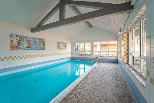 a swimming pool in a house with a large window at Gasthof Gruber in Fridolfing