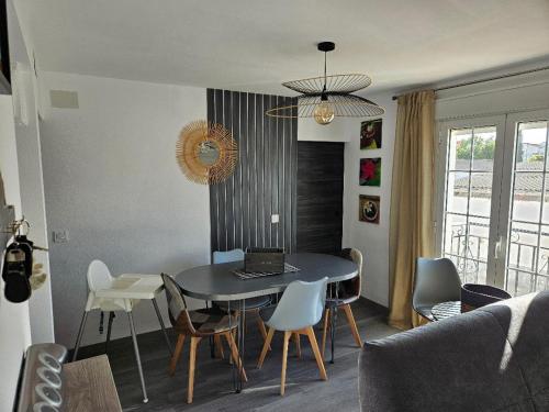 mesa de comedor con sillas y ordenador portátil en Piso Ana appartement Cosy et moderne, Climatisé été, hiver, en Campillos