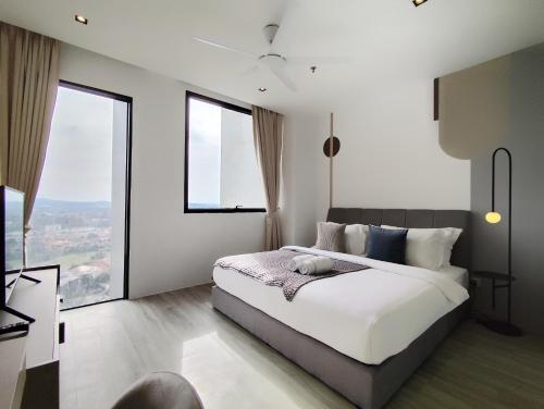 a bedroom with a white bed with large windows at Lumi Tropicana in Petaling Jaya
