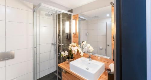 a bathroom with a sink and a glass shower at PLAZA Premium Columbus Bremen in Bremen
