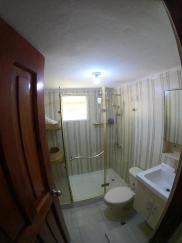 a bathroom with a shower and a toilet and a sink at Hospedaje Villa Valencia en Los Patos in Los Patos