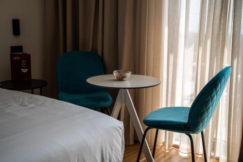 a room with a table and two chairs and a bed at MòN Luxury Rooms SPA in Nicolosi