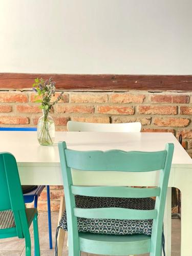 a white table with two chairs and a vase of flowers at Na Bukovku in Těchlovice
