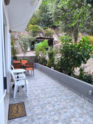 a patio with a table and chairs and plants at Mary's house in Kyparíssion