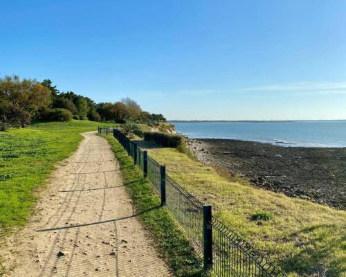 un chemin de terre à côté d'une clôture sur une plage dans l'établissement T1 bis 38m2 avec balcon à 100m de la plage, à La Rochelle