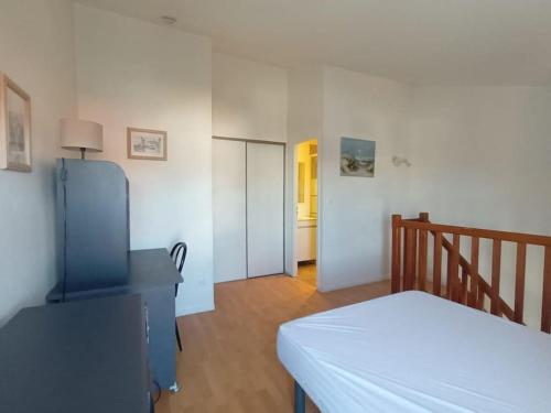 - une chambre avec un lit blanc et un couloir dans l'établissement T1 bis 38m2 avec balcon à 100m de la plage, à La Rochelle