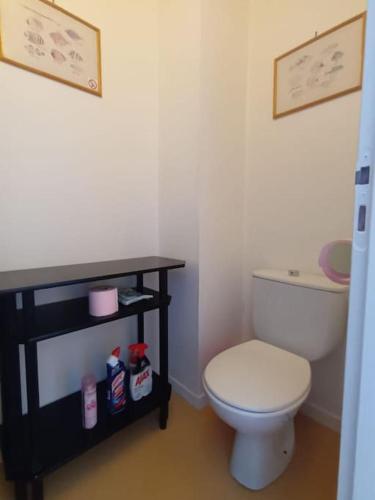 La salle de bains est pourvue de toilettes blanches et d'une table noire. dans l'établissement T1 bis 38m2 avec balcon à 100m de la plage, à La Rochelle