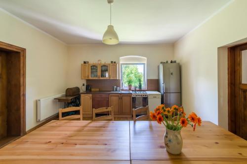 a kitchen with a wooden table and a vase of flowers at Agroturystyka "Pograniczna" in Ober Wüstegiersdorf