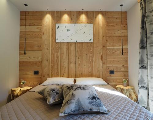 a bedroom with a bed with a wooden wall at Hotel della valle in Vernante