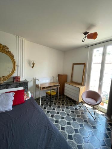 une chambre avec un lit, une table et un miroir dans l'établissement Les jardins de Veronique Marie, à Mèze