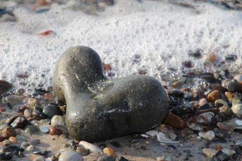 a rock in the shape of a heart on a beach at Meine Fischerhütte in Börgerende-Rethwisch