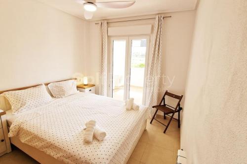 a bedroom with a bed with two teddy bears on it at Lovely Ground Floor 2 Bed with Golf Course Views in Sucina