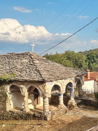 an old stone church with a cross on top at Areti Guesthouse in Víssani
