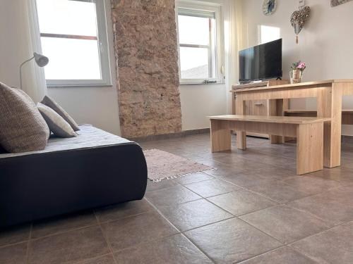 a living room with a couch and a television at DreamWorksApartments-1 in Karlobag