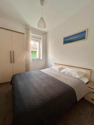 a bedroom with a large bed and a window at DreamWorksApartments-1 in Karlobag