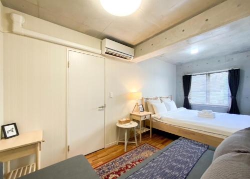 a small room with a bed and a desk and a bed at Uhome Otsuka Villa in Tokyo