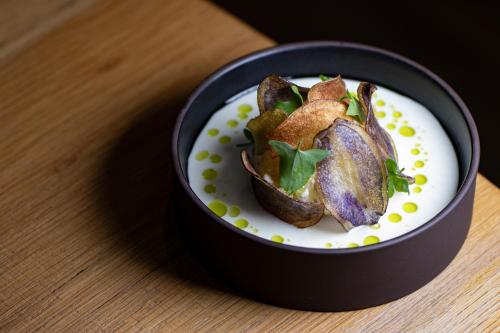 a bowl of food on a wooden table at Bergergut Geniesserhotel in Afiesl